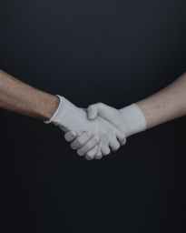 people shaking hands in latex gloves